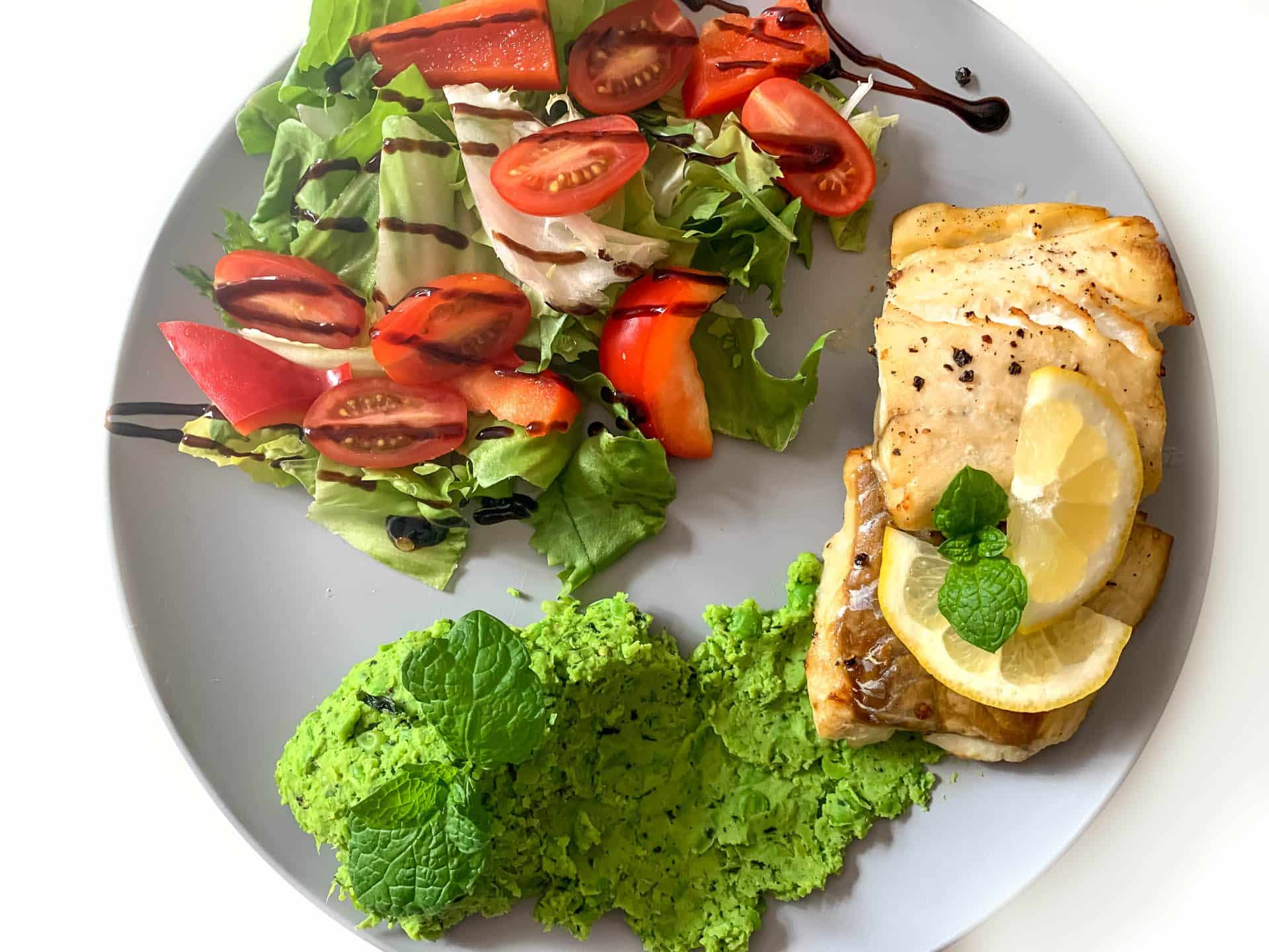 Dorsz z puree z groszku i mięty, sałatką z pomidorkami