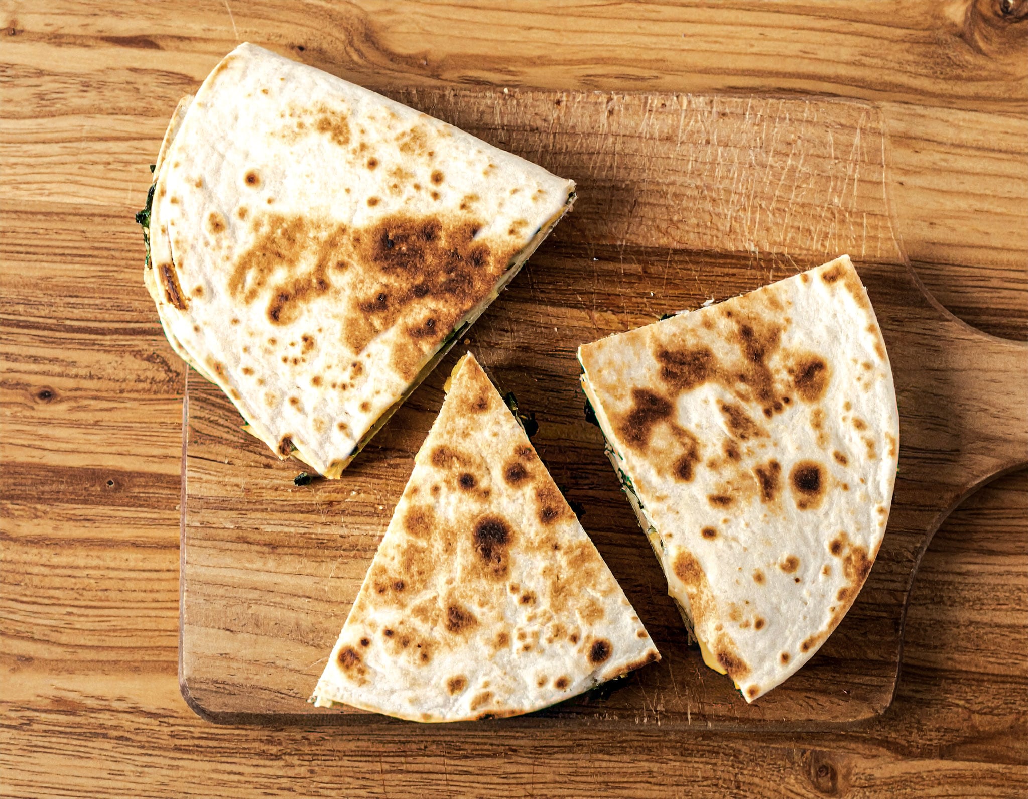 Tortilla z jajkiem, serem i szpinakiem na patelni w kawałkach