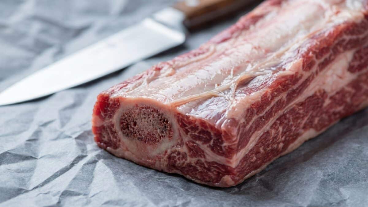 Jakie mięso na rosół? 2 Kawałek surowego szpondra wołowego z kością i przerostami tłuszczu, idealny do gotowania wywaru.